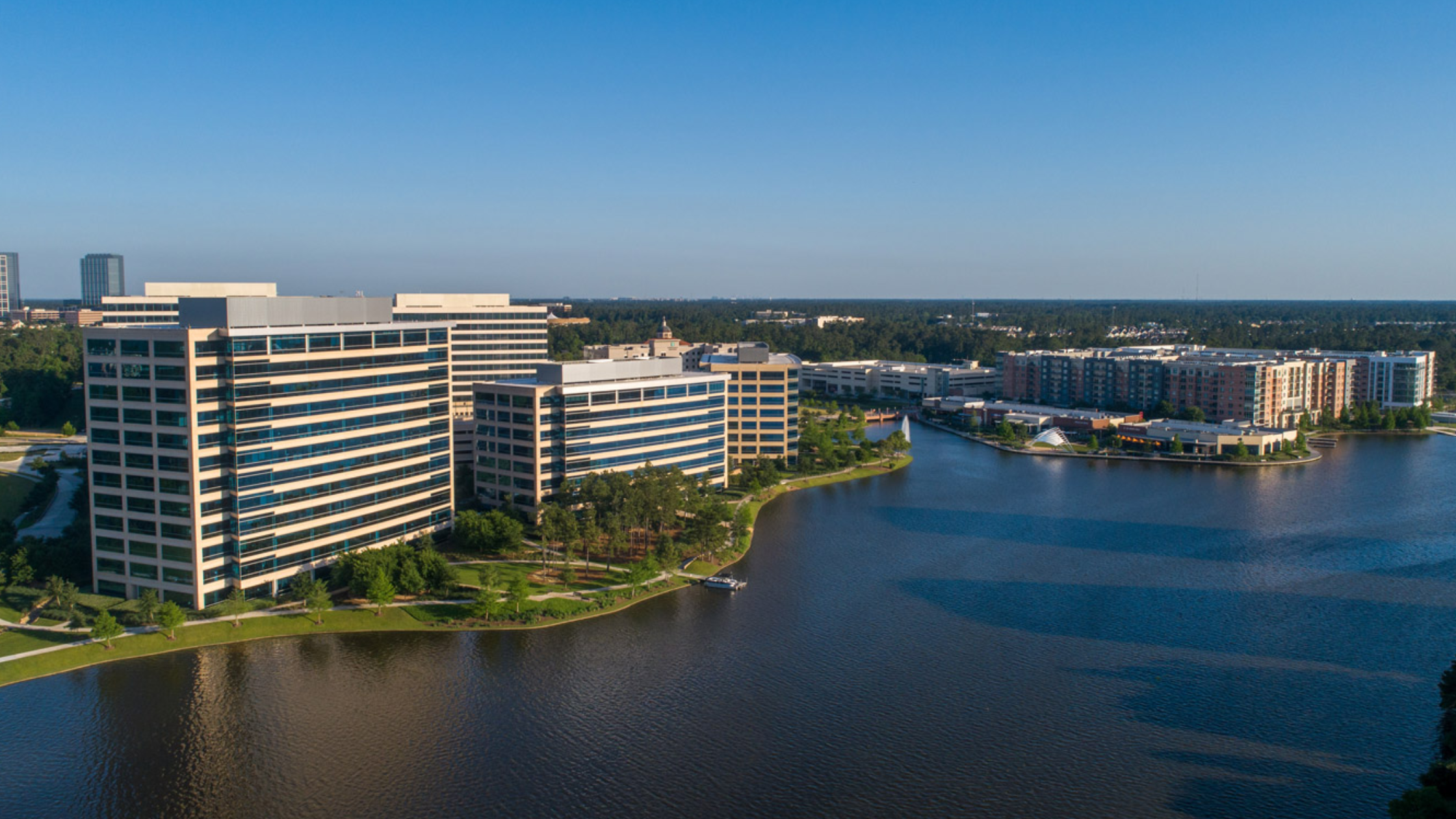 Modern offices and apartments near a lake in The Woodlands, a prime business address with extensive coverage.
