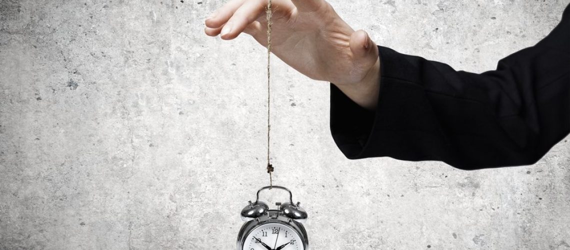 Close-up-of-businessman-holding-clock-on-rope